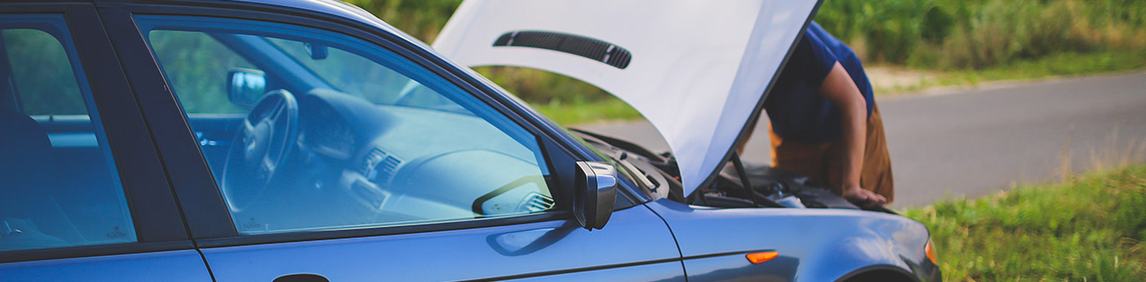 Man looking under the hood of his car