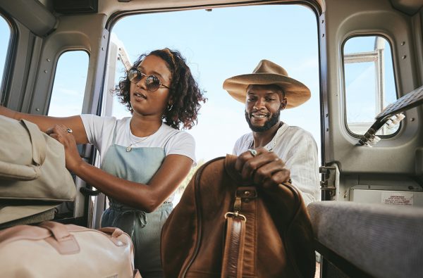 Couple putting luggage in their vehicle