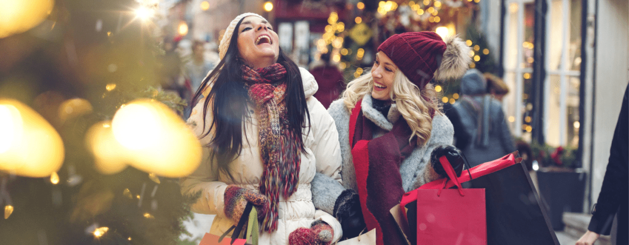 Two women laughing while holiday shopping