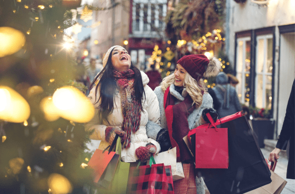 Two women laughing while holiday shopping