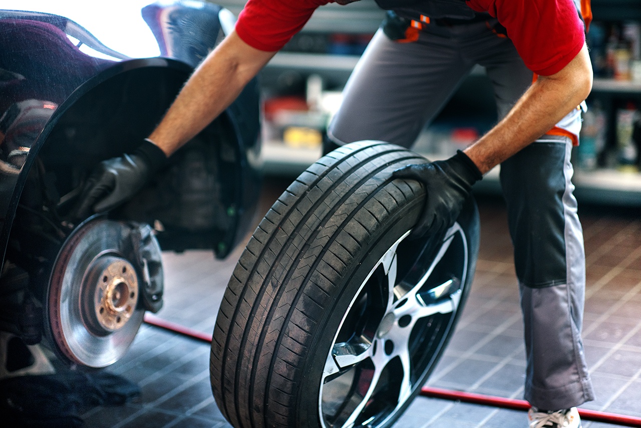 Car mechanic replacing a tire